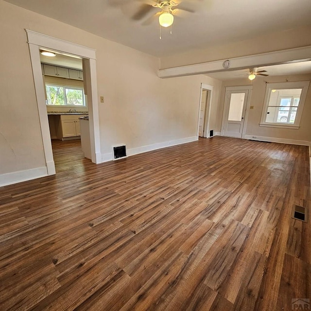 1938 E 6th St, Pueblo, CO 81001 - unfurnished living room with a ceiling fan and dark wood-type flooring
