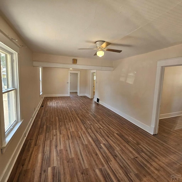 1938 E 6th St, Pueblo, CO 81001 - empty room with dark wood-style flooring, plenty of natural light, and a ceiling fan