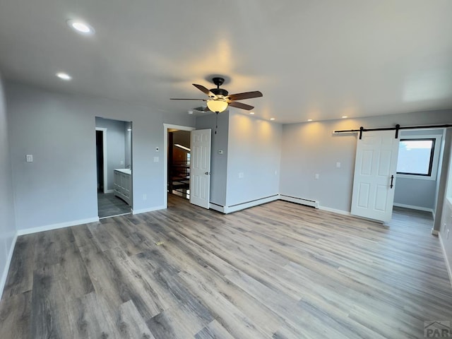 476 S Hahns Peak Ave, Pueblo West, CO 81007 - unfurnished room featuring a barn door, a ceiling fan, recessed lighting, wood finished floors, and a baseboard radiator