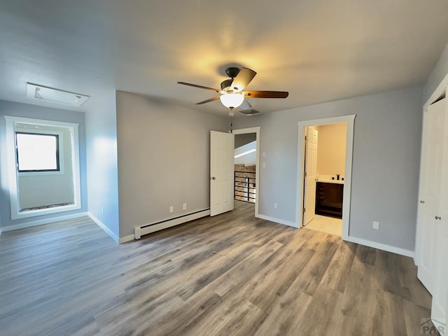 476 S Hahns Peak Ave, Pueblo West, CO 81007 - unfurnished bedroom with baseboard heating, wood finished floors, ensuite bath, and ceiling fan