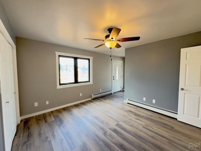 476 S Hahns Peak Ave, Pueblo West, CO 81007 - unfurnished bedroom with a baseboard radiator, wood finished floors, and a ceiling fan