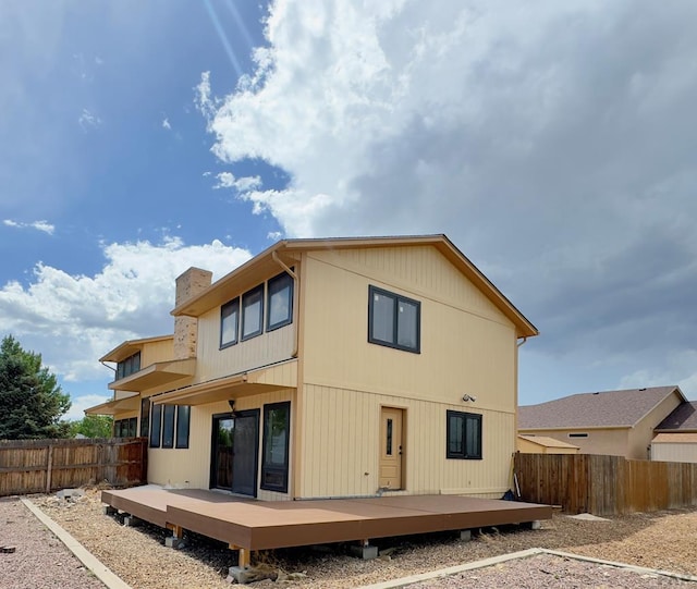 476 S Hahns Peak Ave, Pueblo West, CO 81007 - rear view of house with a fenced backyard, a deck, and a chimney