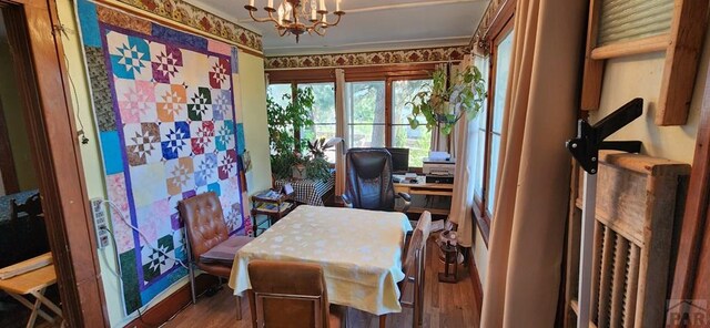 home office featuring wood finished floors and an inviting chandelier