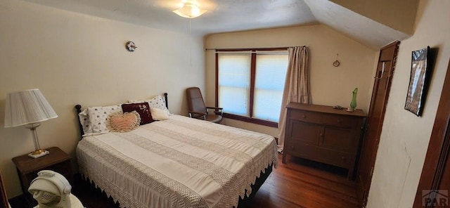 bedroom featuring lofted ceiling and dark wood-type flooring