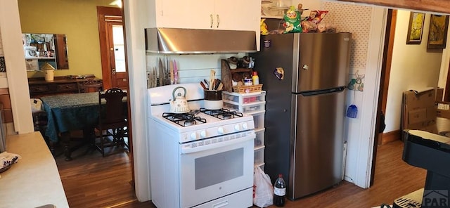 kitchen featuring extractor fan, white range with gas stovetop, white cabinets, light countertops, and freestanding refrigerator