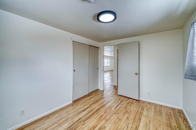 empty room with light wood finished floors and baseboards