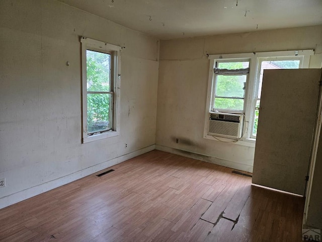 00913 6th St, Walsenburg, CO 81089 - unfurnished room featuring cooling unit, wood finished floors, and healthy amount of natural light