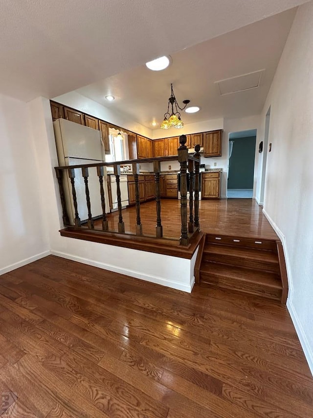 stairs with wood finished floors, attic access, and baseboards