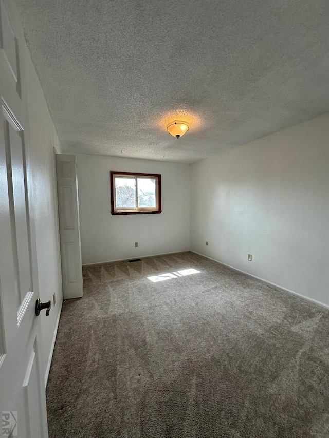 unfurnished room featuring a textured ceiling and carpet flooring