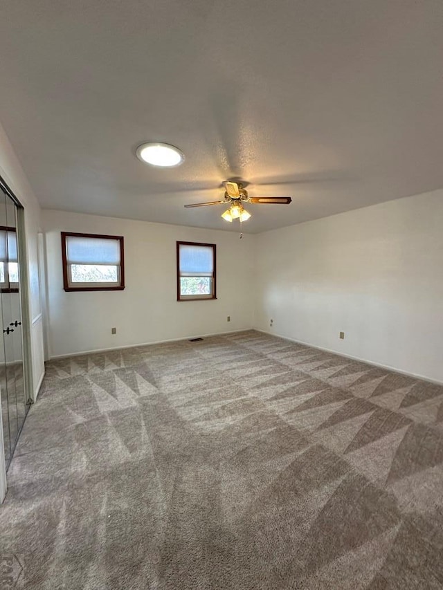 spare room with ceiling fan, carpet flooring, and visible vents