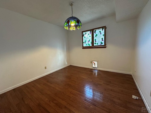 unfurnished room featuring dark wood-style floors, baseboards, and a textured ceiling