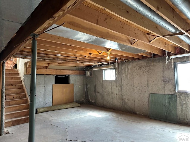 basement featuring stairs and electric panel