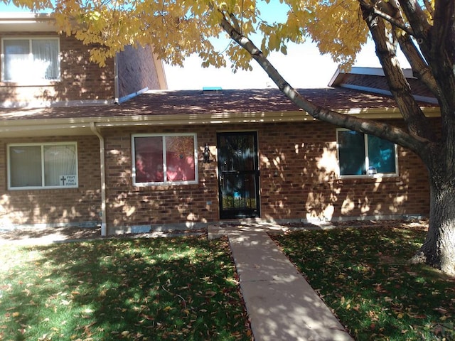 view of front facade featuring a front yard and brick siding