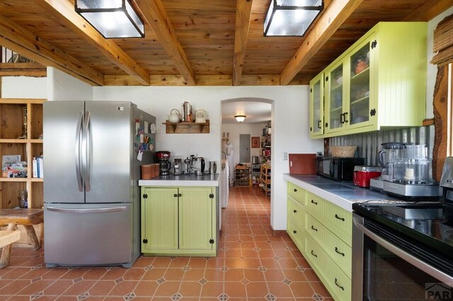 2793 Black Fawn Ln, Westcliffe, CO 81252 - kitchen featuring green cabinetry, appliances with stainless steel finishes, arched walkways, a wooden ceiling with exposed beams, and tile patterned floors