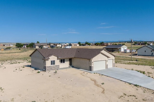 single story home with an attached garage, driveway, and stucco siding