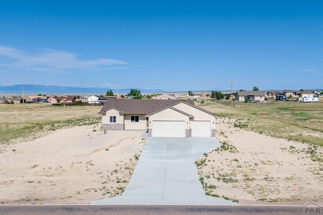 ranch-style house with a garage, driveway, and stucco siding