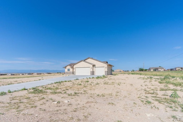 exterior space with an attached garage, driveway, and an outdoor structure