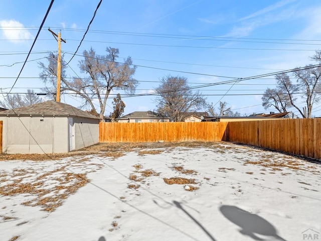 yard layered in snow with a fenced backyard