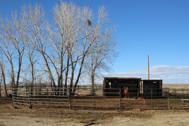 view of yard with an exterior structure, a rural view, and an outdoor structure