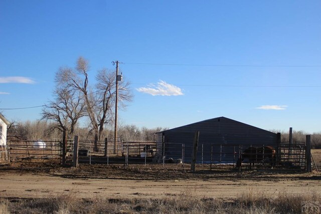 view of yard featuring an exterior structure, an outbuilding, and a rural view