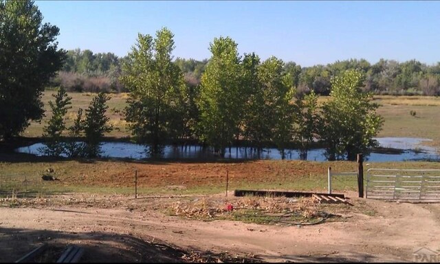 view of water feature with a rural view and fence