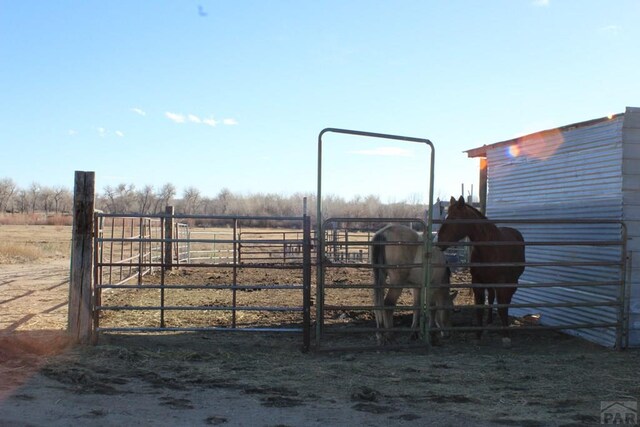 view of gate with a rural view, an outdoor structure, and an exterior structure