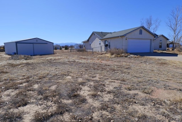 view of home's exterior featuring a pole building, fence, and driveway