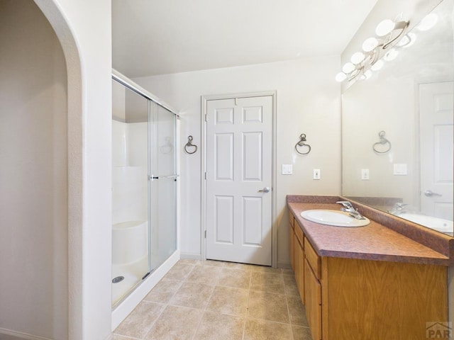 bathroom featuring tile patterned flooring, a shower stall, and vanity