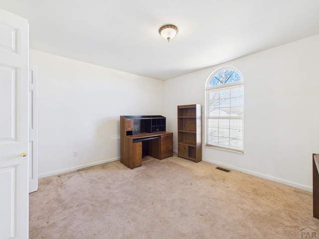 carpeted office space featuring visible vents and baseboards