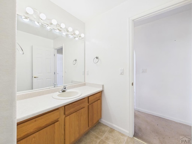 bathroom with tile patterned flooring, baseboards, and vanity