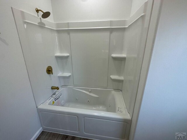 bathroom with a combined bath / shower with jetted tub, baseboards, and wood finished floors