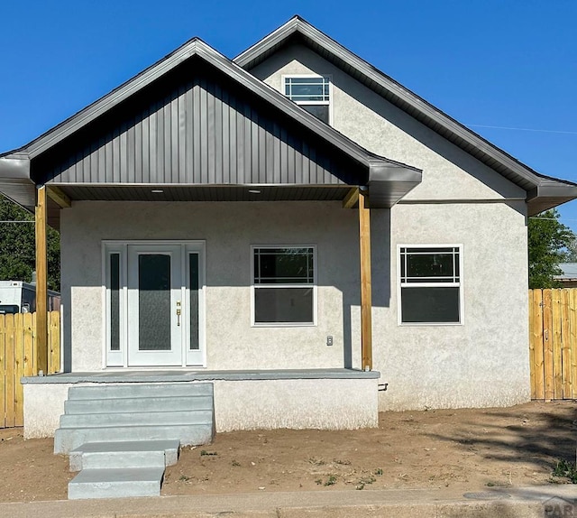 bungalow featuring fence and stucco siding