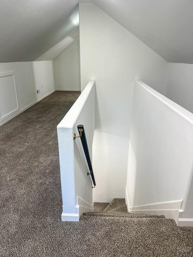 additional living space featuring vaulted ceiling, carpet flooring, and baseboards