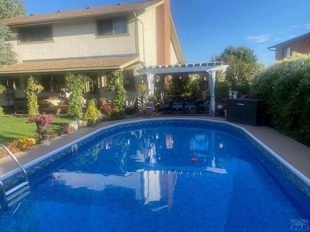 outdoor pool featuring a pergola and a patio