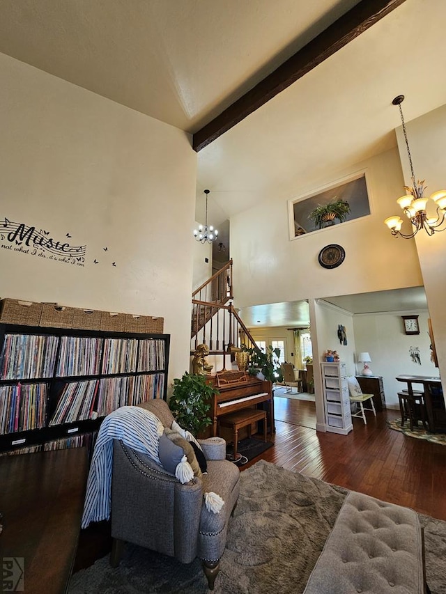 living area with stairway, beam ceiling, a high ceiling, wood-type flooring, and a chandelier