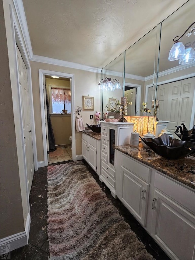 full bathroom featuring baseboards, toilet, ornamental molding, and vanity