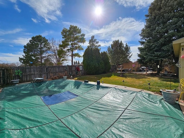 view of swimming pool featuring fence, a yard, and a diving board