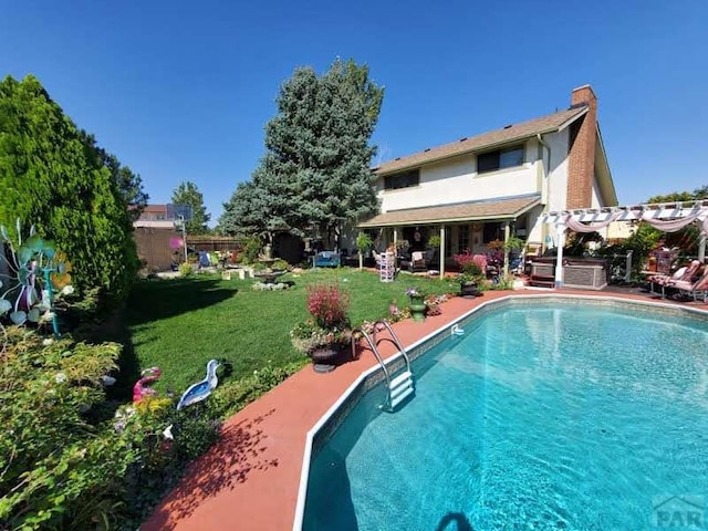 pool with a patio, a lawn, and fence