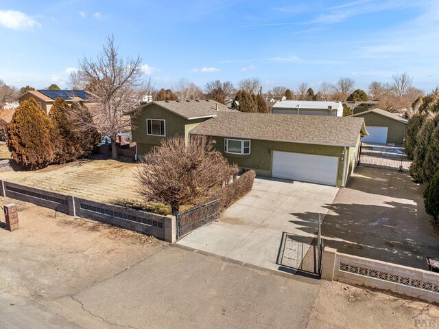 ranch-style house with a fenced front yard, stucco siding, an attached garage, a residential view, and driveway