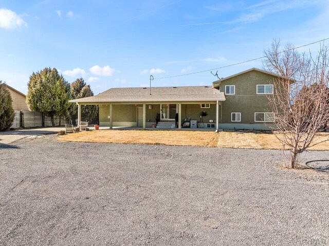 ranch-style home featuring fence and stucco siding