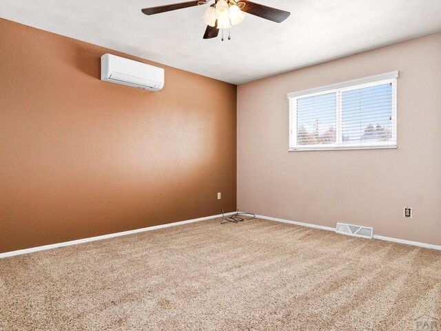 carpeted empty room with a ceiling fan, a wall unit AC, visible vents, and baseboards