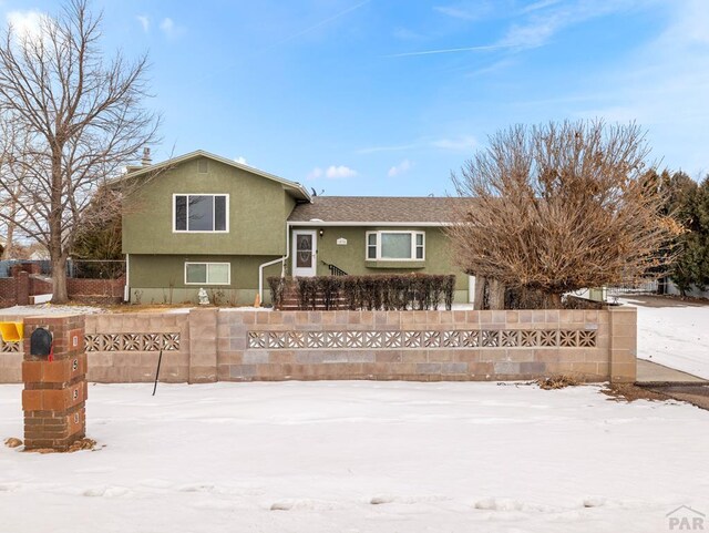 view of front of house with a fenced front yard and stucco siding