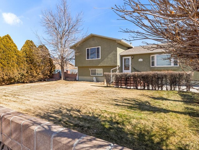 exterior space with a lawn and stucco siding