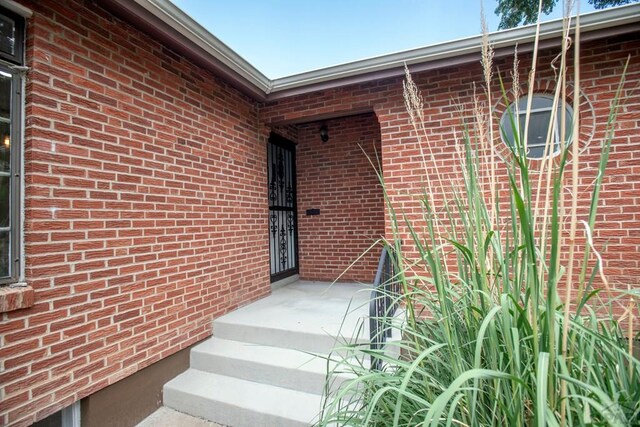 doorway to property with brick siding