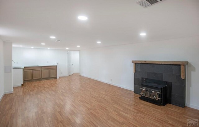 unfurnished living room with recessed lighting, baseboards, visible vents, and light wood finished floors