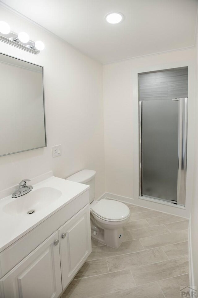 full bath with toilet, a shower stall, and vanity