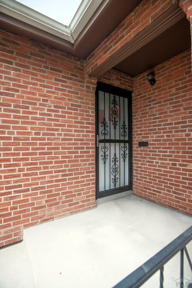 entrance to property featuring brick siding