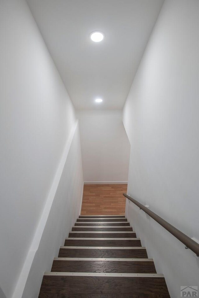 staircase featuring wood finished floors and recessed lighting