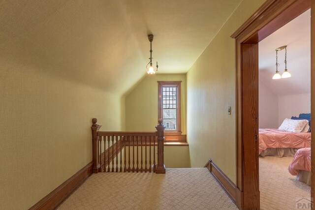 additional living space with vaulted ceiling, baseboards, and light colored carpet