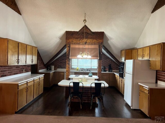 kitchen with brown cabinets, lofted ceiling, pendant lighting, and light countertops